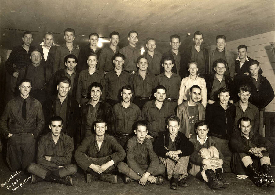 Group portrait of CCC men from Barracks B in the Cataldo CCC Camp. Writing on the photo reads: 'Barracks B Company 967 Camp F-114 Leo's'.