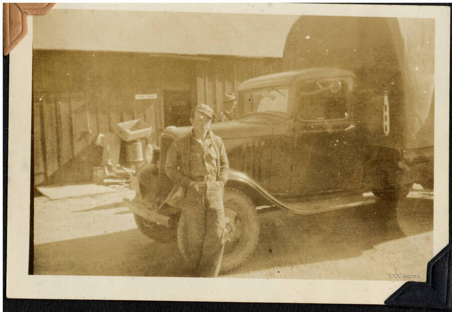 Man standing in front of a covered truck, SCS-1. From the Paul Saft photographic album, SCS-1, C-1503, Moscow, Idaho, 1938-39, depicting camp life, taken mostly in the Moscow, Lewiston, Robinson Lake area, 1938-39