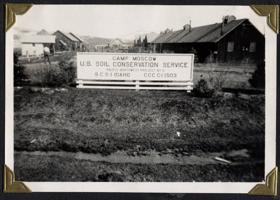 Camp Moscow sign in front of camp buildings. SCS-1, C-1503. From the Paul Saft photographic album, SCS-1, C-1503, 1938-39, depicting camp life, taken mostly in the Moscow, Lewiston, Robinson Lake areas.