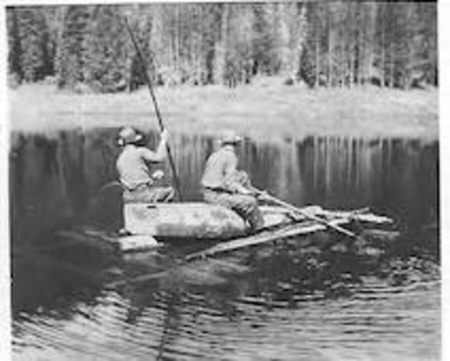 Two men rowing a small boat or pontoon. Captioned: 'lake above camp'. Camp Smith Ferry, 1939.