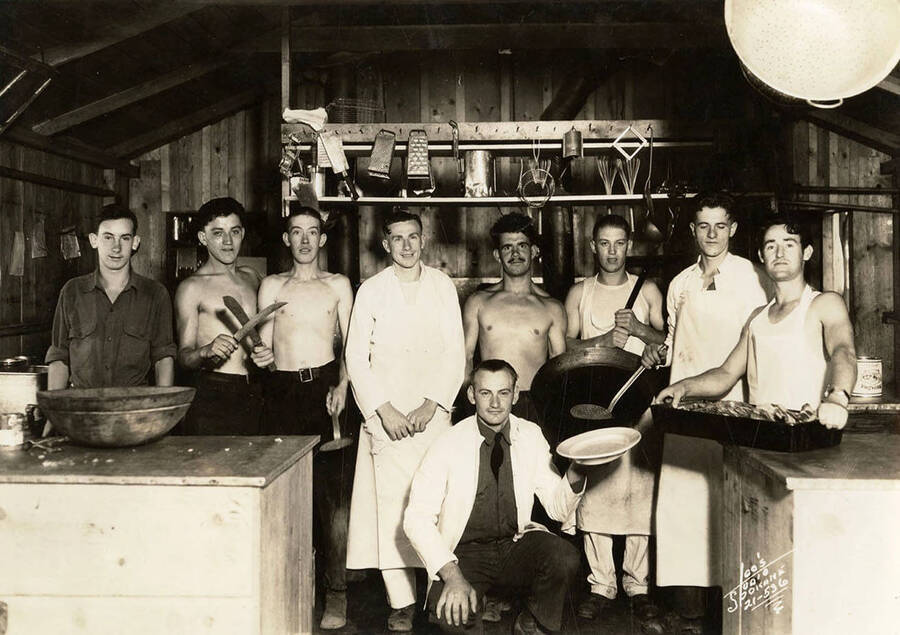 Group portrait of cooks and KP workers in the kitchen at Grizzly CCC Camp, F-136. Writing on the photo reads: 'Leo's Studio Spokane'.