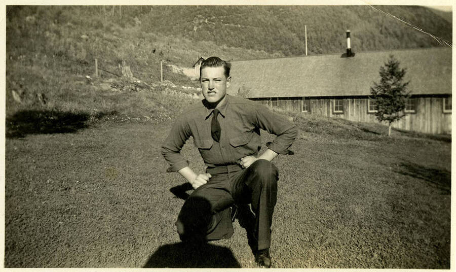 A photograph of possibly Louis Brown posing crouched in front of a building. Back of photograph reads, "Brown Louis."