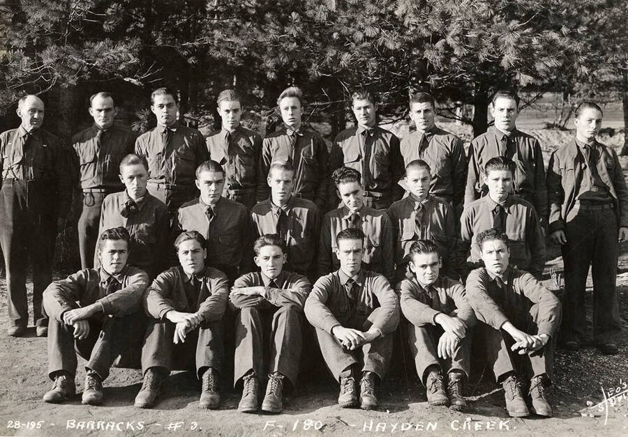 Group portrait of CCC men at Hayden Creek CCC Camp. Writing on the photo reads: 'Barracks #3 F-180 Hayden Creek Leo's Studio'.
