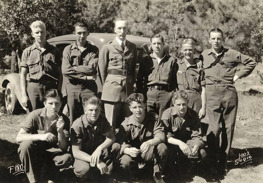 Group portrait of CCC men at Hayden Creek CCC Camp. Writing on the photo reads: 'F-180 Leo's Studio'.