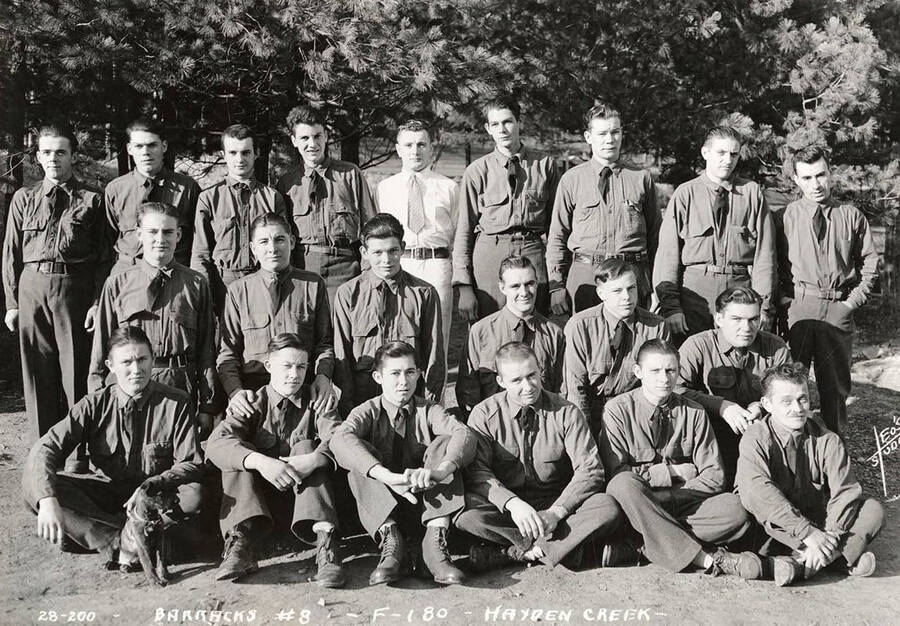 Group portrait of CCC men at Hayden Creek CCC Camp. Writing on the photo reads: 'Barracks #8 F-180 Hayden Creek Leo's Studio'.