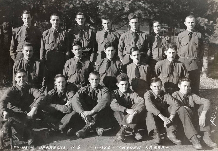 Group portrait of CCC men at Hayden Creek CCC Camp. Writing on the photo reads: 'Barracks #6 F-180 Hayden Creek Leo's Studio'.