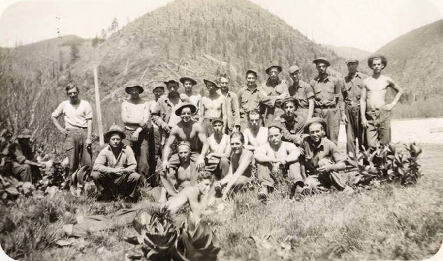 Group portrait of CCC men, likely from Magee CCC Camp. Back of photo reads: 'left to right Overdorf (seated), Homer Jacobs, Ingerlund (foreman), [Farmer Sons], Chester Webster, Dejarnette, McKeown, D. Lepper (right front)'.