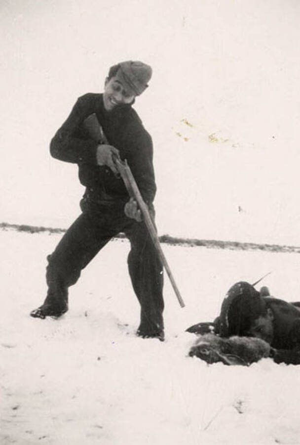 Two CCC men goofing off and posing for a picture in the snow after having shot a rabbit. Back of photo reads: 'Playing soldier in the snow 1935. Arrow Photo Service Box 184 Minneapolis, Minnesota.'