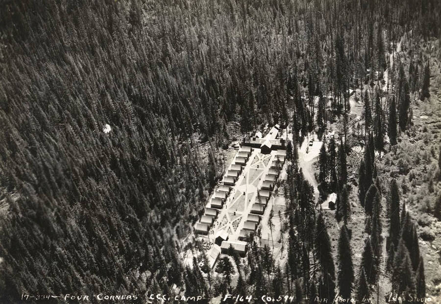 Aerial view of CCC Camp Four Corners, F-164. Writing on the photo reads: 'Four Corners CCC Camp F-164 Company 594 Air photo by Leo's Studio'. Back of photo reads: 'Four Corners Priest River Kaniksee, National Forest'.