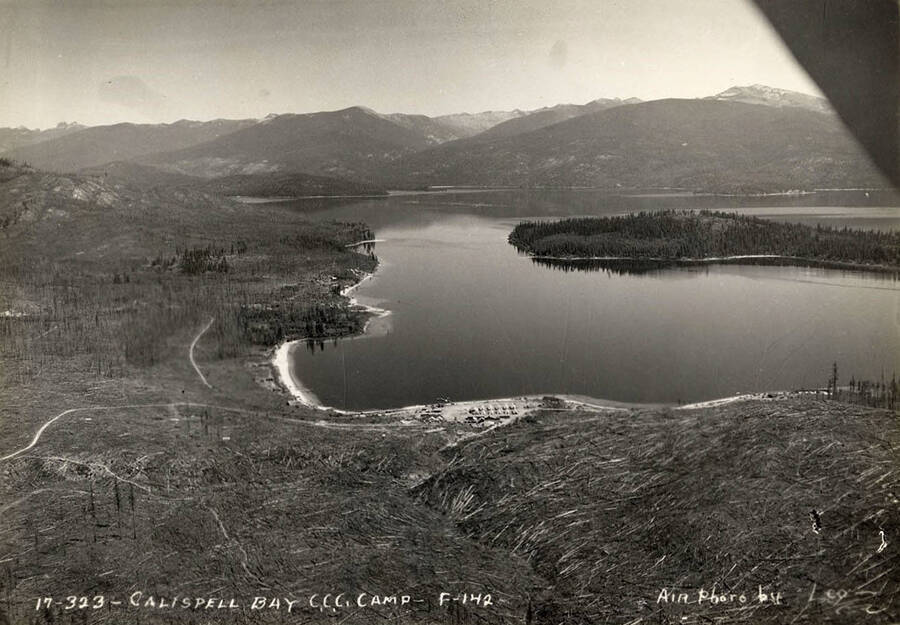 Aerial view of Kalispell Bay and the CCC Camp stationed there, F-142. Writing on the photo reads: 'Calispell Bay CCC Camp F-142. Air photo by Leo's Studio'.