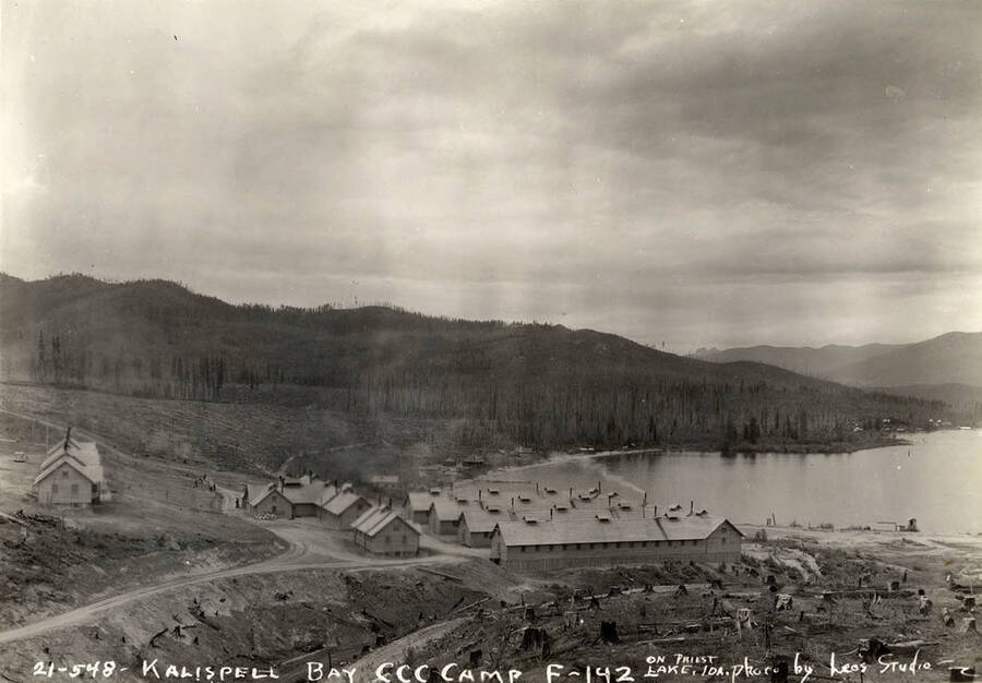 View of the CCC Camp at Kalispell Bay, F-142. Writing on the photo reads: 'Kalispell Bay CCC Camp F-142 on Priest Lake, Idaho Photo by Leo's Studio'.