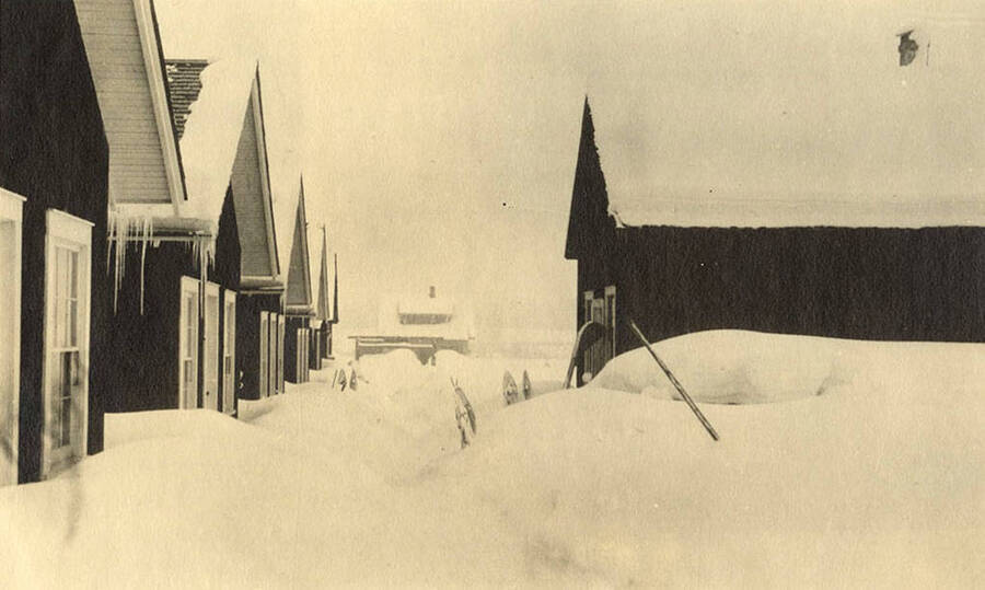 View of a CCC Camp in winter and snow. Back of photo reads: 'Winter Scene at CCC Camp at [dusk].'