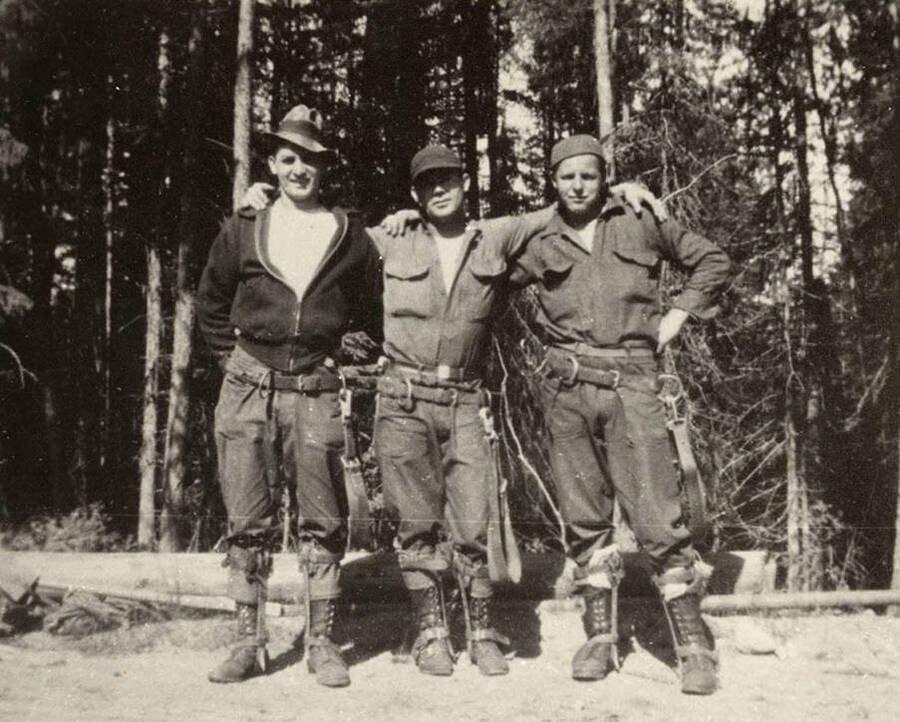 Group photo CCC construction crew members on Hunt Peak. The workers were connecting a telephone line to the Fire Lookout Tower. The man in the center is crew foreman, Leo Black, from Big Creek Camp F-127. Back of the photo reads: 'CCC Telephone line construction crew working on Hunt Peak telephone line to Fire Lookout. Crew foreman in center Leo Black from Big Creek Camp F-127, 1935. Leo Black photo. Chuck Peterson Copy.