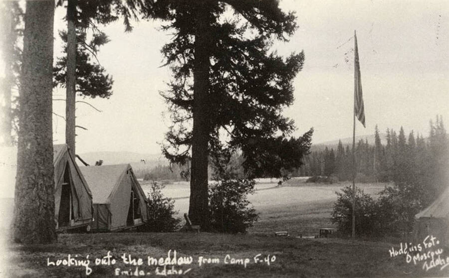 View of tent barracks and meadow at CCC Camp Santa Creek, F-40, near Emida, Idaho. Writing on the photo reads: 'Looking onto the meadow from camp F-40 Emida, Idaho Hodgins Fot. Of Moscow, Idaho'.
