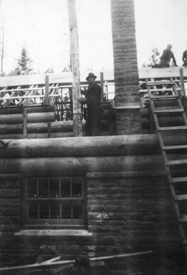 Lodge under contruction at Heyburn State Park. Men pose on top the structure.