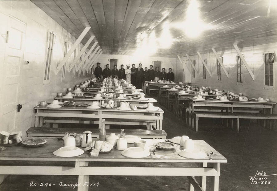 Group photo of CCC men in the mess hall at Marble Creek Camp, F-117. Writing on the photo reads: 'Company 240 Camp F-117 Leo's Studio'. Back of photo reads: 'Marble Creek'.