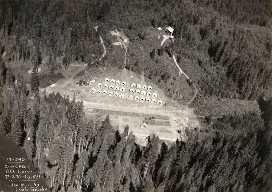 Aerial view of Cow Creek Camp, P-270 Company 531.  Writing on the photo reads: 'Cow Creek CCC Camp P-270 Company 531 Air photo by Leo's Studio'. Back of photo reads: 'Cow Creek'.