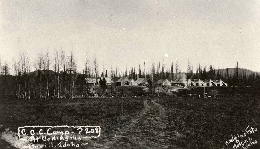 View of CCC Camp Collins, P-208 (also F-141), near Bovill, Idaho. Writing on the photo reads: 'CCC Camp P-208 At Collins Bovill, Idaho Hodgins Foto Moscow, Idaho'. Back of photo reads: 'Clearwater National Forest Collins'.