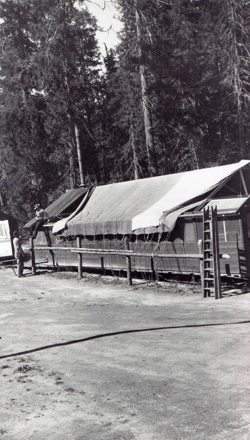 Putting tarp roof on spike camp building.