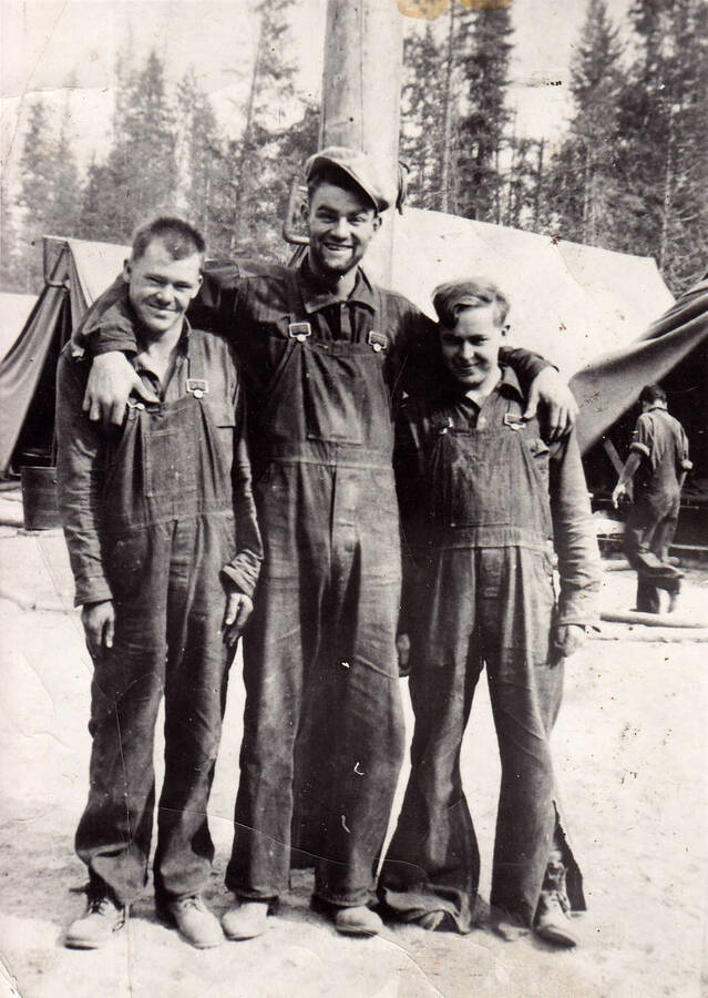 Three enrollees of company C-535 posing for a photo during the summer of 1934, at camp F-163 near Priest River Idaho. The back of the photo reads 'Four Corners Summer 1934 - CCC Company 535 Priest River, Idaho. Ed (Orzenski?) Claude (Smaully?) Ive Pullum'.
