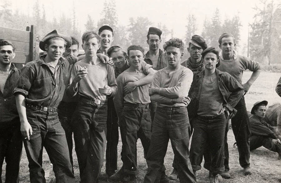 Group photo of CCC men posing at the CCC Spirit Lake Fire Camp. Stamp on back of photo reads: 'If this photo is reproduced credit must be given as follows: 'Photo by K.D. Swan, courtesy U.S. Department of Agriculture, Forest Service.''