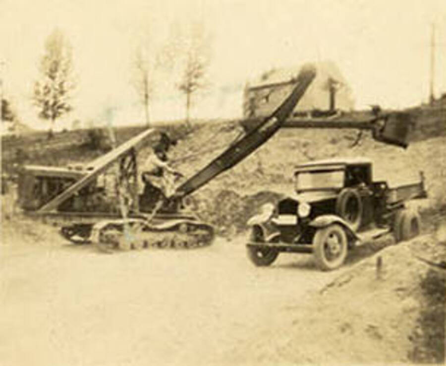 Steam shovel loading a truck at Wolf Lodge Beauty Bay by CCC workers. Back of photo reads: 'Wolf Lodge Beauty Bay'.