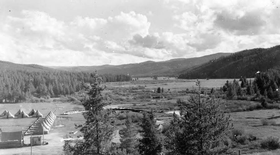 A view of CCC Camp Red River, F-102, Company 573, in the Valley. Back of photo reads: 'Red River Valley 1939 CCC Camp to left. C.J. Porlutner St. Gertrude's Museum Civilian Conservation Corps'.