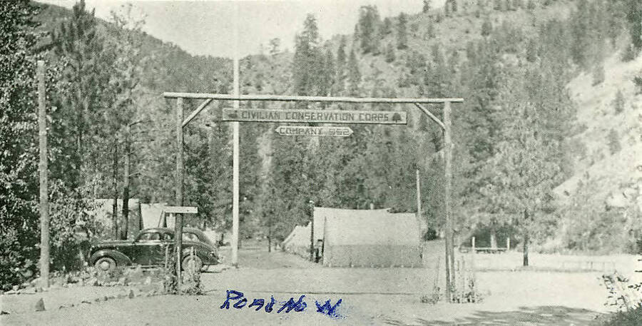 Wooden sign to entrance of tent camp reads 'Civilian Conservation Corps Company 952'. Handwritten note reads: 'Road No. N'.