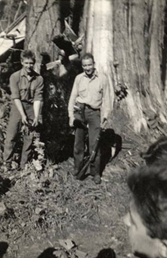 Two CCC men standing by a bear  they had shot. The back of the photo reads: 'Doctor and his bear. Bird Creek, Idaho. September 1938.'