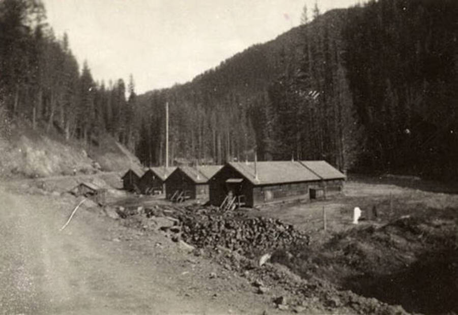 A view of CCC Camp, F-187, the surrounding river, and the valley. The back of the photo reads: 'Company 1239 F-187 August 1938'.