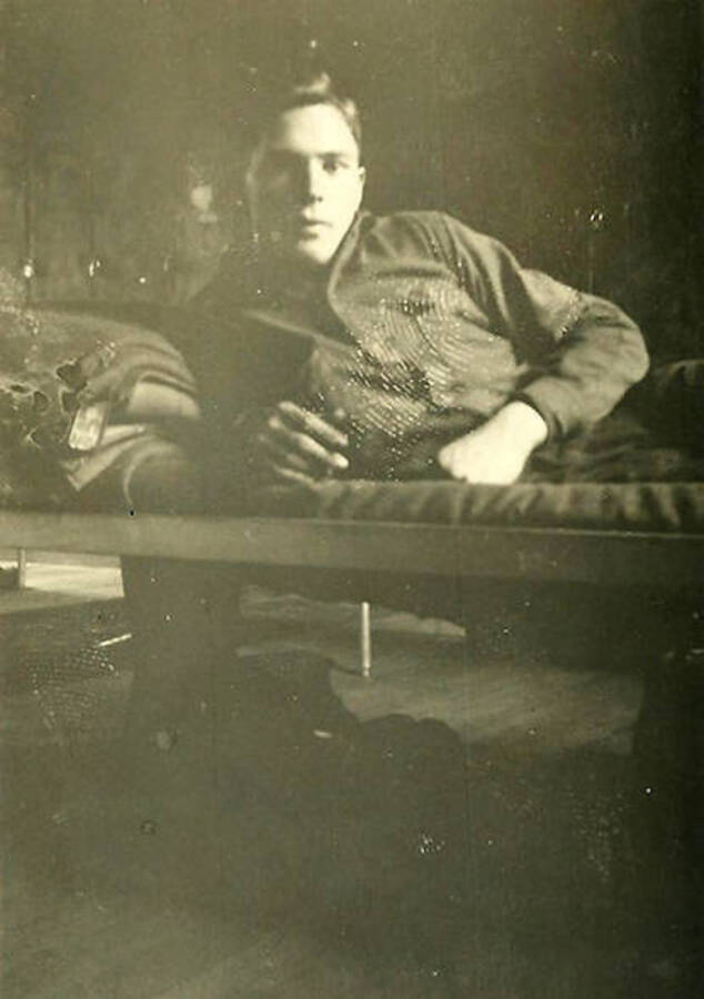 A CCC man poses on his cot inside one of the barracks at CCC Camp Big Creek #2, F-132. Back of the photo reads: 'Fred Lokant from oak hill, W. Va.'