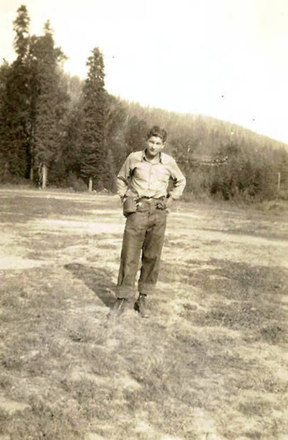 A CCC man poses in a field. CCC Camp Big Creek #2, F-132.