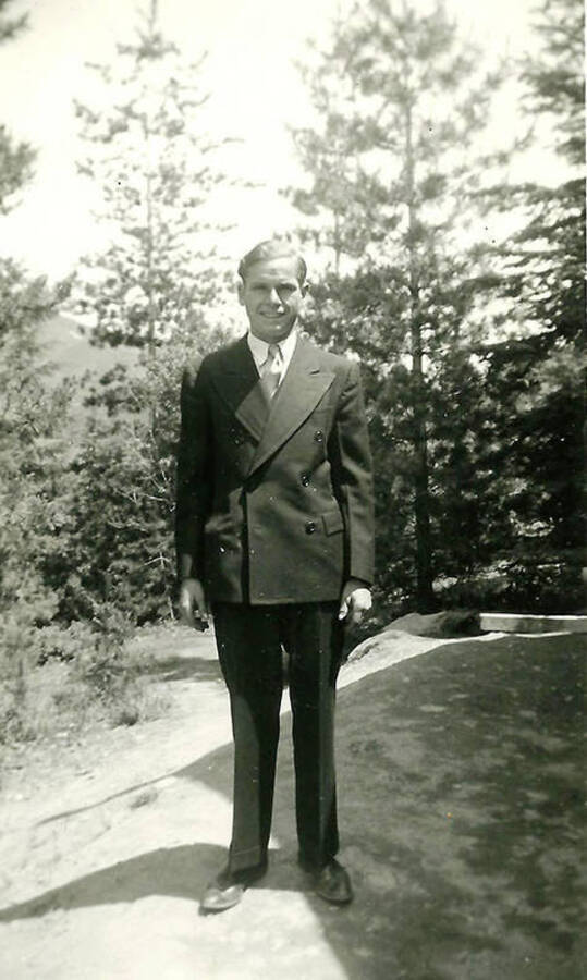 A CCC man posed in a suit and jacket at CCC Camp Big Creek #2, F-132. Back of the photo reads: 'Ed Sash - ready to ship out for home.'