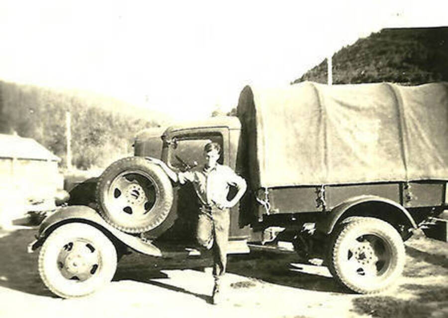 A CCC man poses in front of a CCC truck at CCC Camp Big Creek #2, F-132.