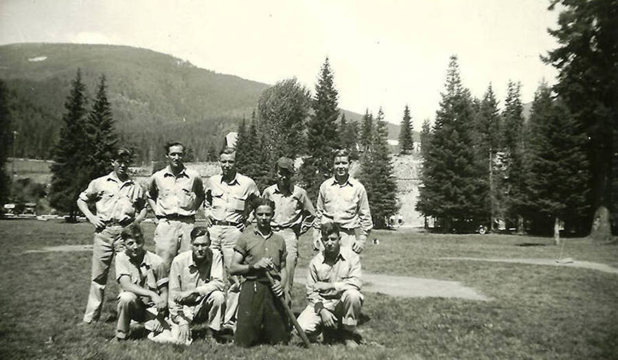 Several CCC men pose together on a baseball diamond.