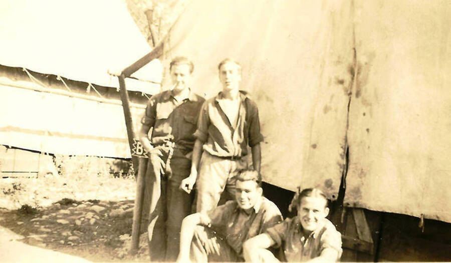 Four CCC Men standing in front of one of the tent barracks. A small sign marks it as Barracks 'B'.