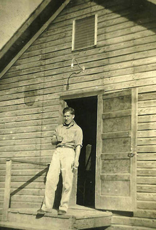 A CCC man stands in front of the Barracks at CCC Camp Big Creek #2, F-132.