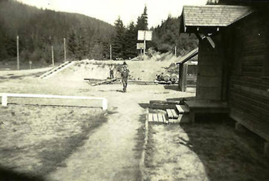 A photo of CCC men in CCC Camp Big Creek #2, F-132. Back of photo reads: 'Taken 1937 This view was taken in front of the headquarters building looking towards the basketball court.'