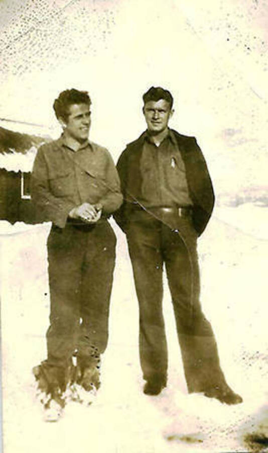 Two CCC men posed in the snow outside of CCC Camp Big Creek #2, F-132.