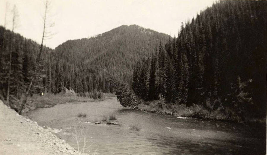 A view of the St. Joe River and the wooded hills surrounding. Back of the photo reads: 'St. Joe River, Idaho. August 1938.'
