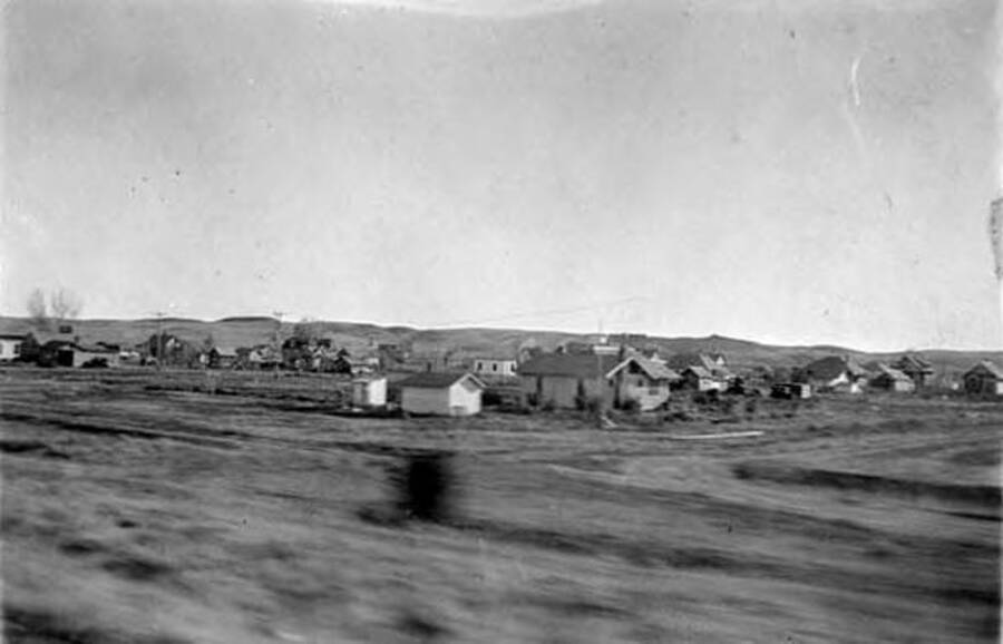 A photo from the train of a small Montanan town. Writing next to the photo reads: 'A Town in the West Mont.'