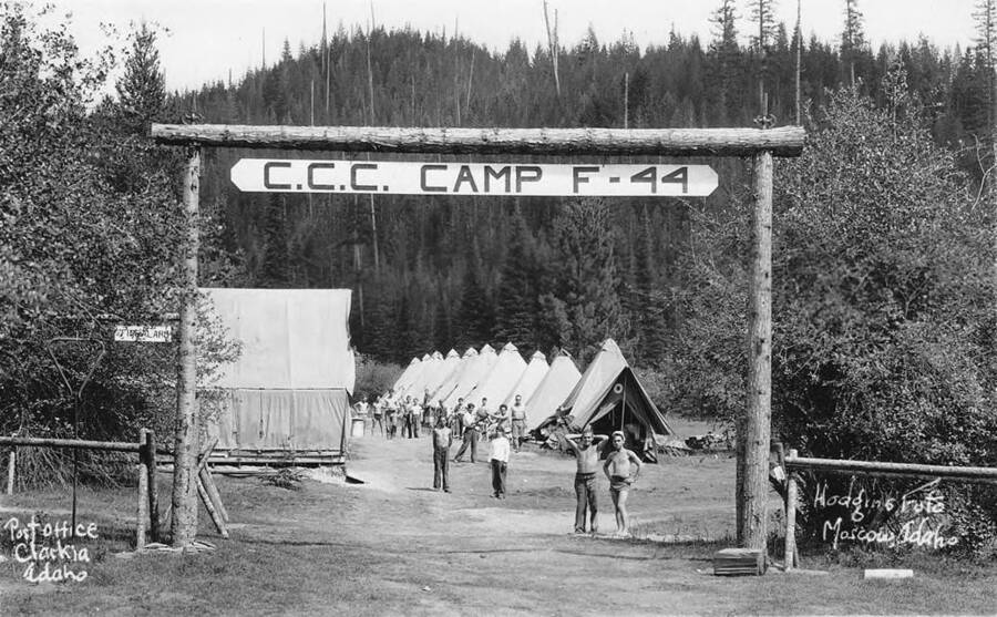 A view of CCC Camp F-44 near Clarkia, Idaho. The sign reads: 'CCC Camp F-44' The small sign reads: 'Fire Alarm'. The writing on the photo reads 'Post Office Clarkia Idaho. Hodgins Foto Moscow, Idaho.
