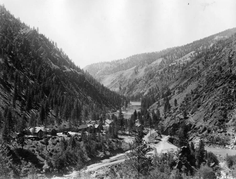 A CCC Camp sits on a plateau in a river valley surrounded by wooded hills.