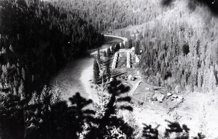 Aerial photo of Camp O'Hara from east. The camp sits along the bank of a river, surrounded by forested hills.