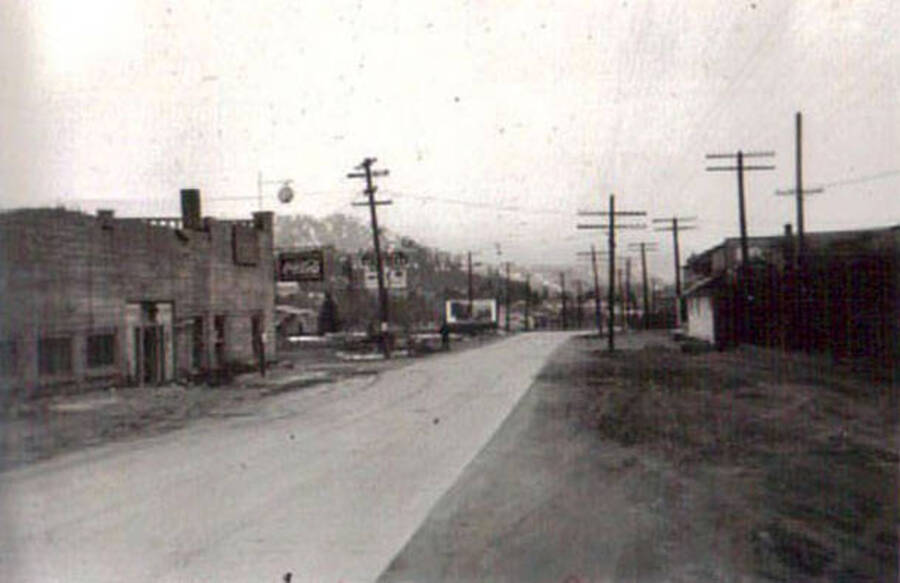 Photo of a town street with several businesses and telephone poles.  Writing under the photo reads: 'Dryden Wash'.