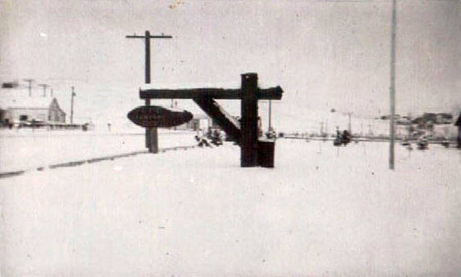 Photo of a CCC camp sign. The camp is covered in a layer of snow.
