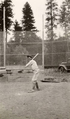 A CCC man posing with a bat over home plate.