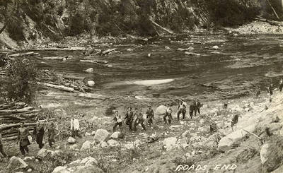 A company of CCC men walking along the bank of the Salmon River. Construction on the Salmon River Road was given up and the road was never completed. Writing on the photo reads: 'Roads End'.