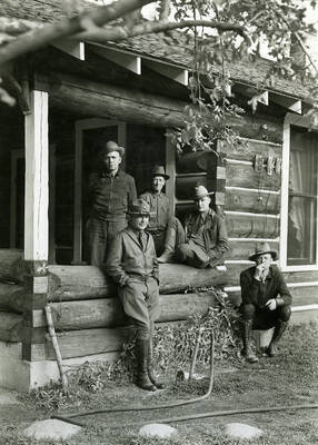 A line of army staff, for CCC companies 251 & 283, stand under a welcome banner for the National Geographic Society at CCC camp French Creek F-109.