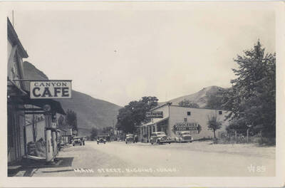 Postcard of Riggins, Idaho in the late-30s. Features Canyon Cafe and the Golden Rule store in the background as well as classic cars and a fuel station. Picture was probably taken around the time of the construction of the Salmon River Road.